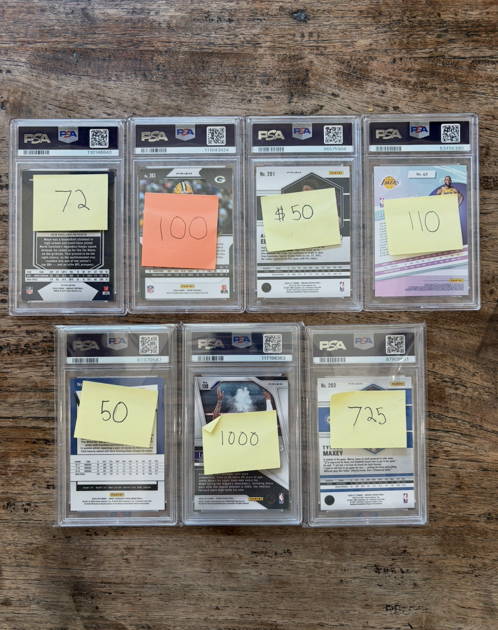 Stack of graded PSA slabs — backs with prices